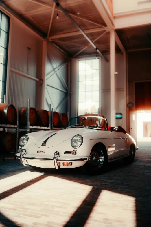 an old white sports car sitting in a building