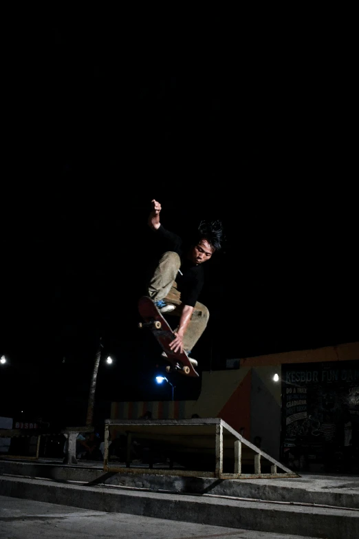a man riding a skateboard in the air at night