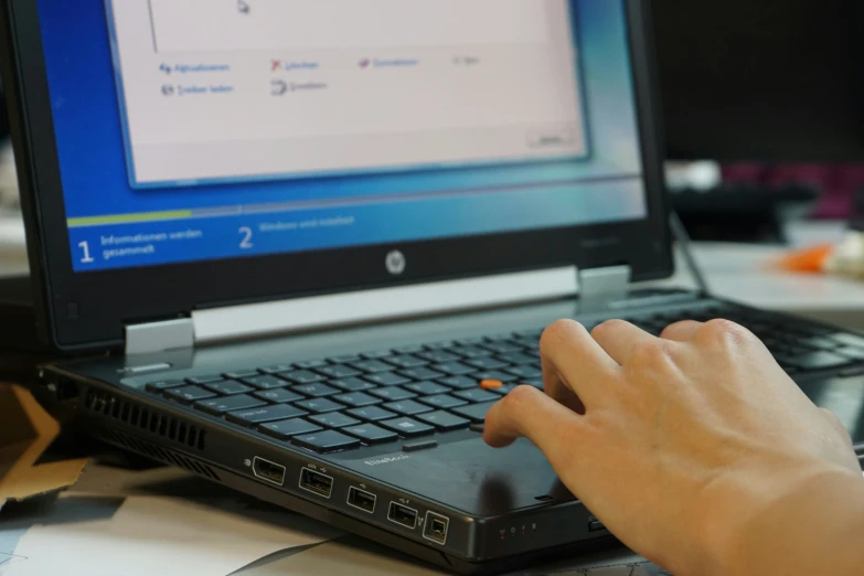 a person is using a laptop that has their hands on the keyboard