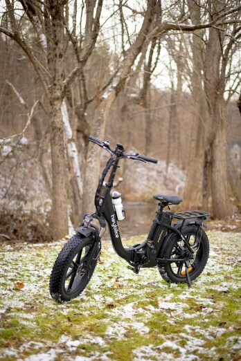 an electric bicycle with a big tire is parked on grass