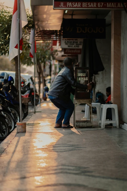 a woman bending over at a counter on a sidewalk