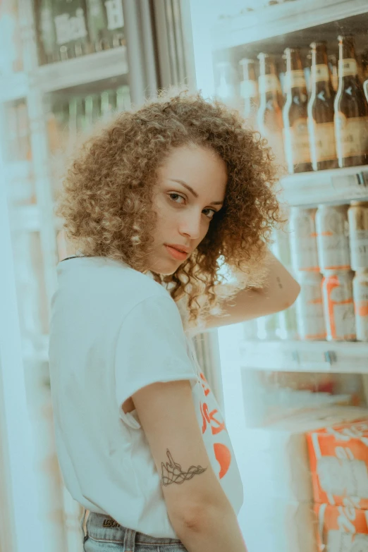 a woman stands in front of a refrigerator with cold beverages on it