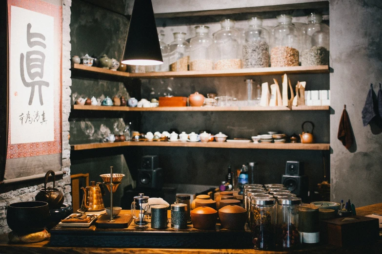 jars, a mug, cups and other items sit on wooden shelves