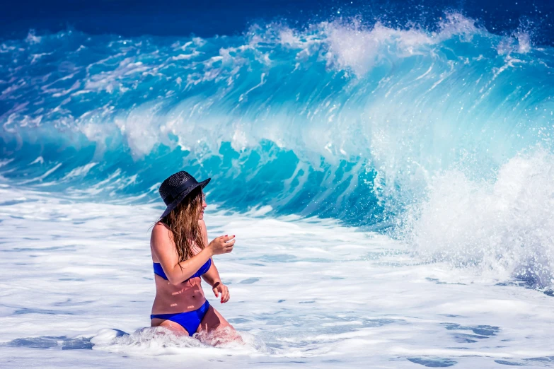 a woman in the water looking at a wave