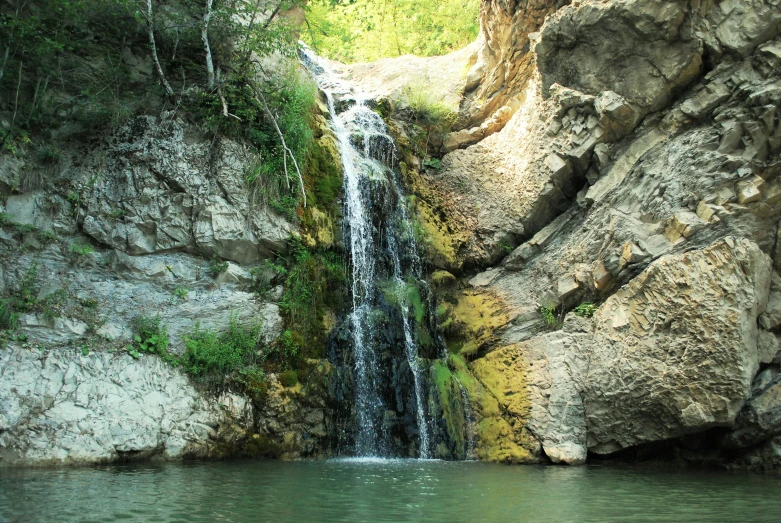 the large waterfall is next to a cliff