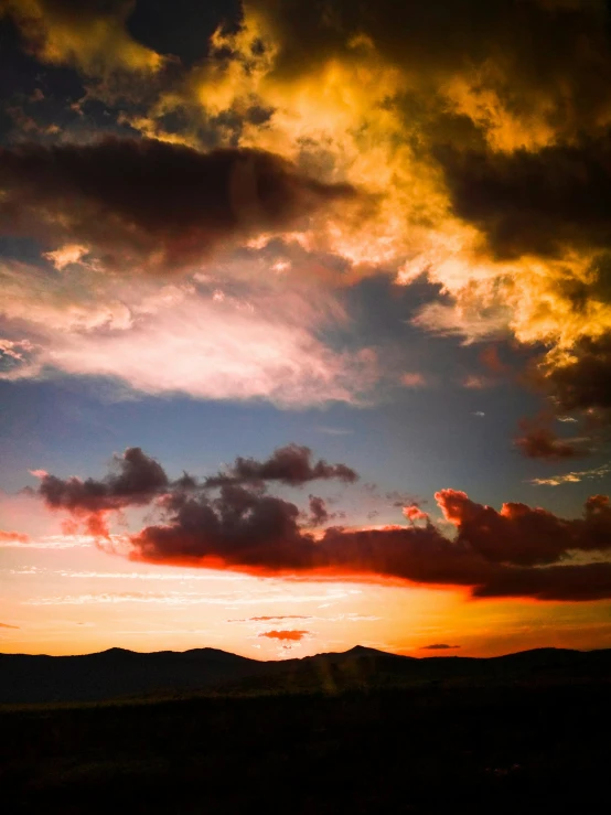 a big sky with clouds that are yellow and red