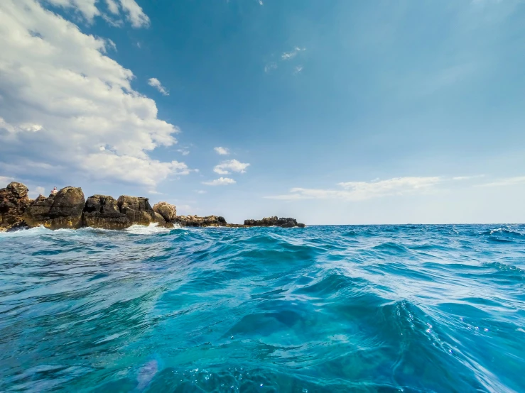 blue water with rock formation in the background