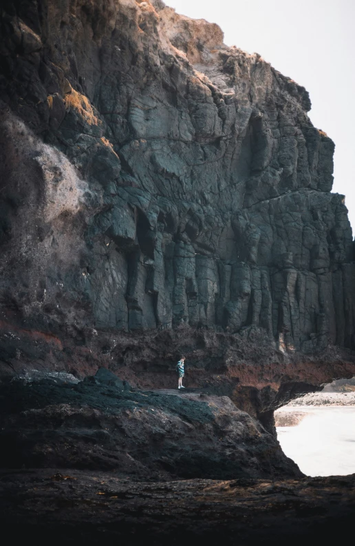 an image of man standing in front of cliffs