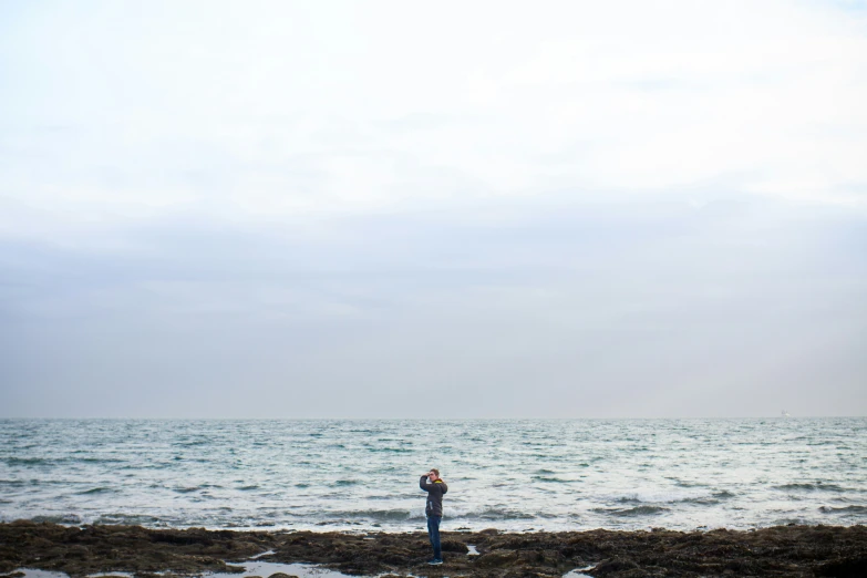 a person stands in the sea with his back turned