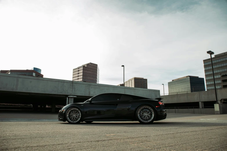 black sports car parked next to tall buildings