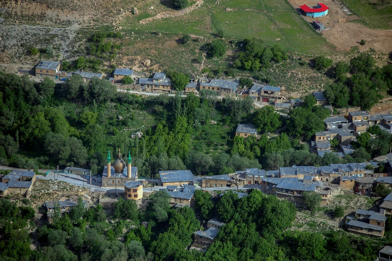 a red plane is flying over a town