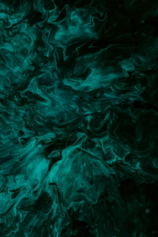 an aerial po of green, fluid ink in the dark