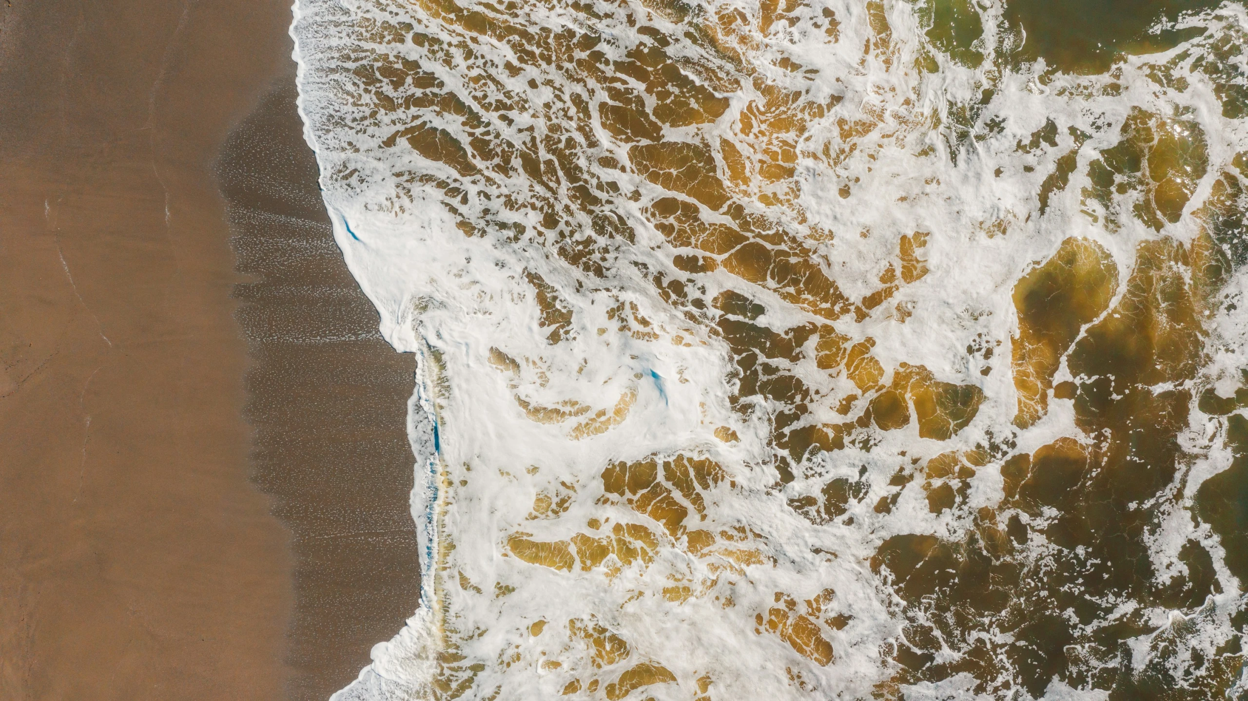 the water and sand from above looking down at the beach