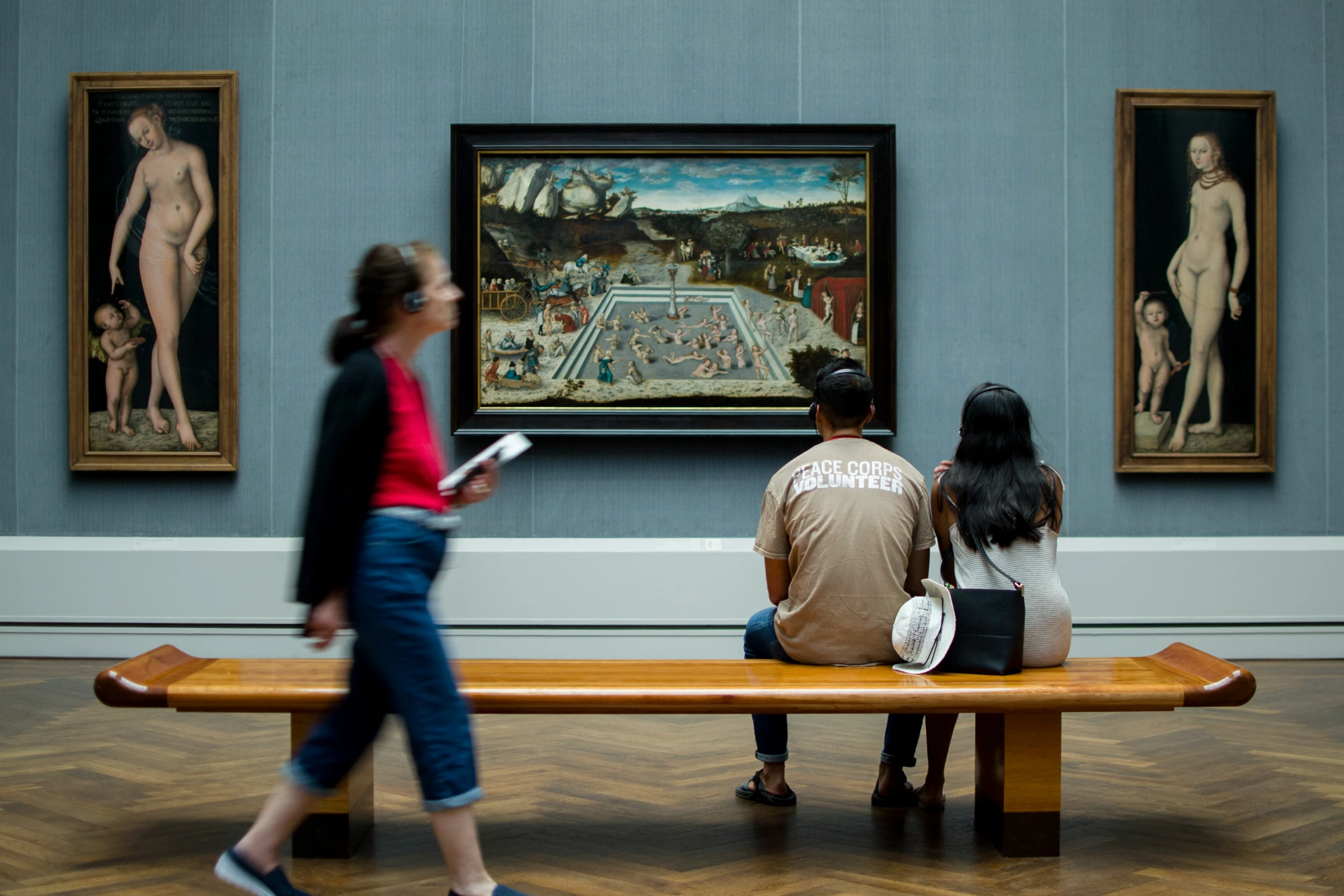 three young people sit on a bench in a museum