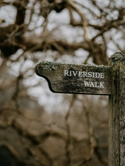 a sign with an arrow pointing towards the riverside walk