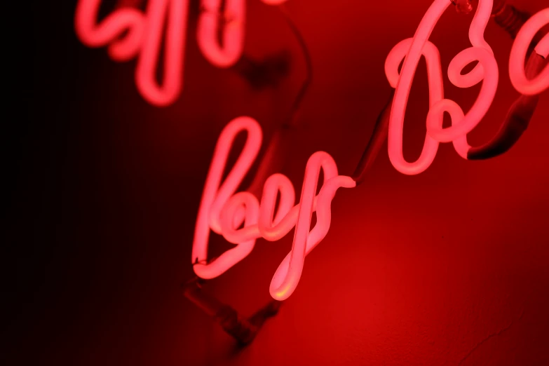 two neon signs that read boojubs in front of a wall