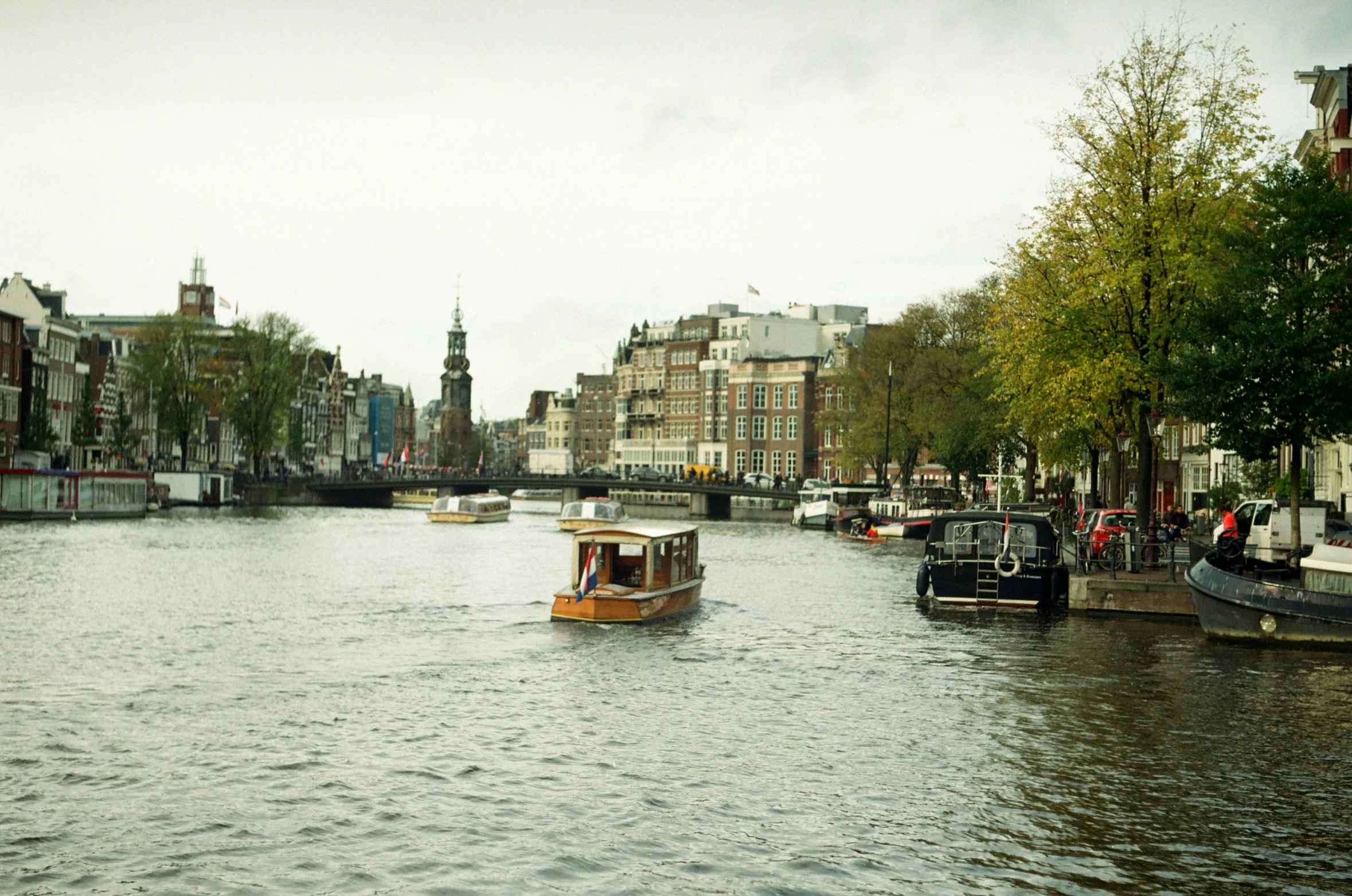 a boat is going down a waterway that has some buildings and boats