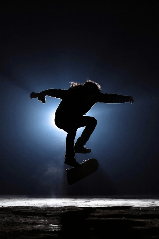 a skateboarder doing tricks in the dark sky