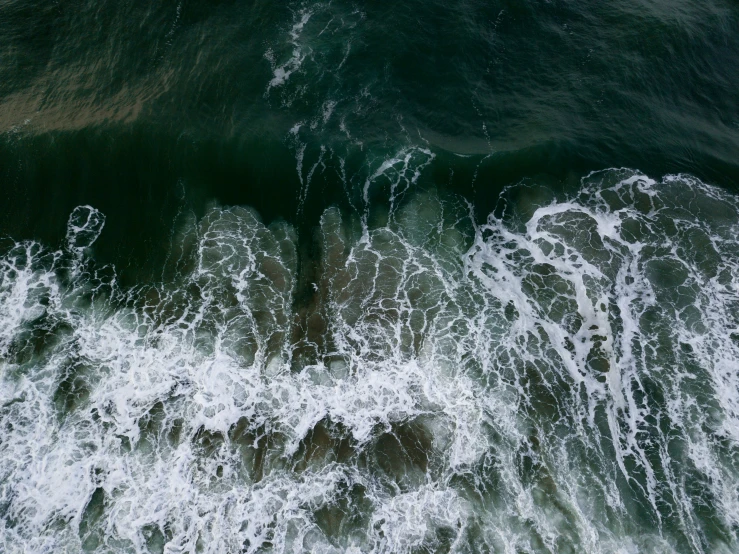 an aerial s of the ocean waves and rocks