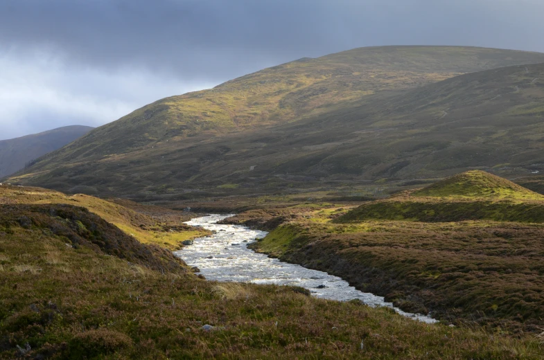 a river is flowing through a wide hilly area