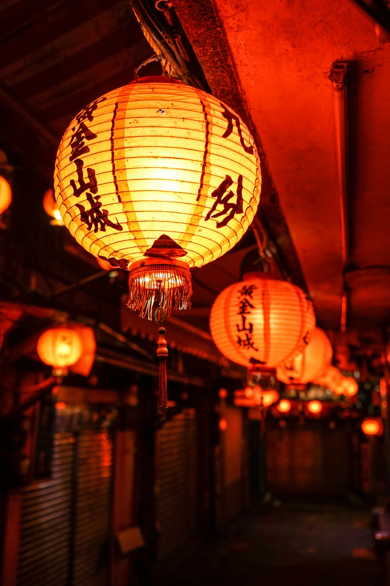 a number of asian lights hanging from a ceiling