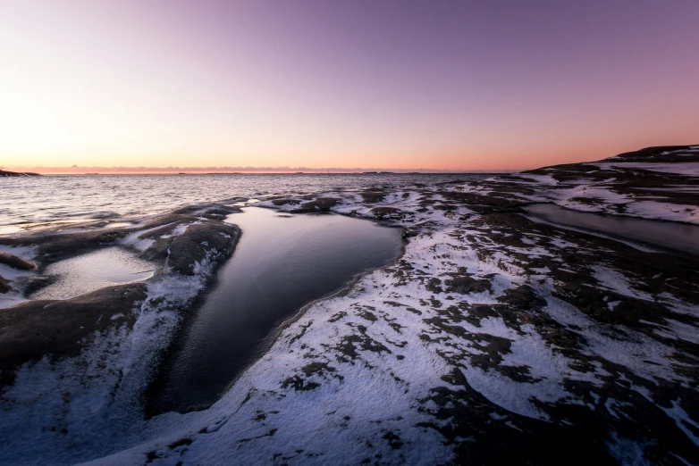 a lake is frozen with snow on the ground