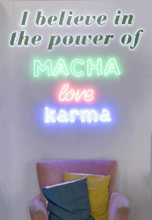 a neon sign reads i believe in the power of macha love karma