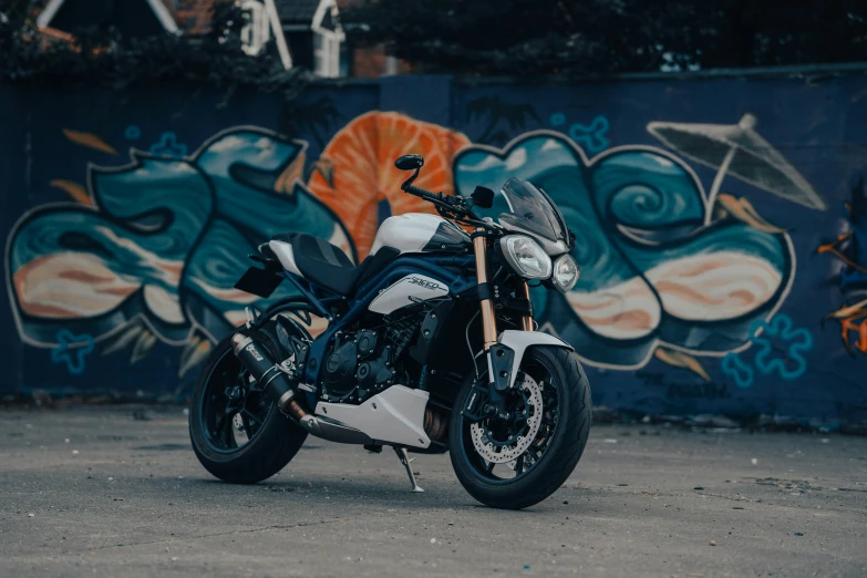 the motorcycle is parked next to a colorful wall