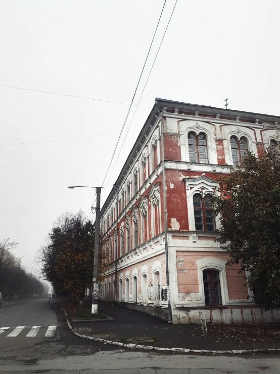 an old building sits in the middle of a street