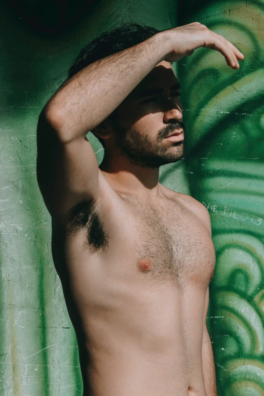 a man in bathing trunks stands by a wall