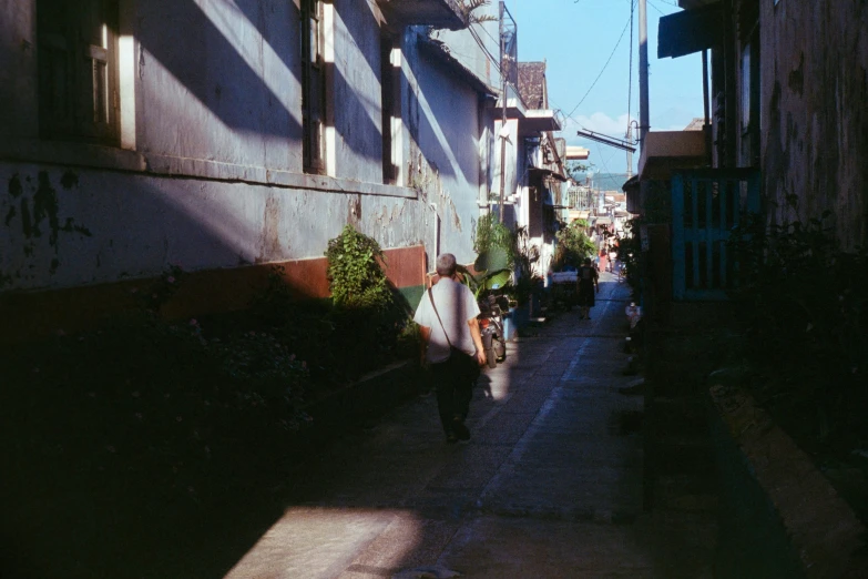 people walking down the street with a surfboard