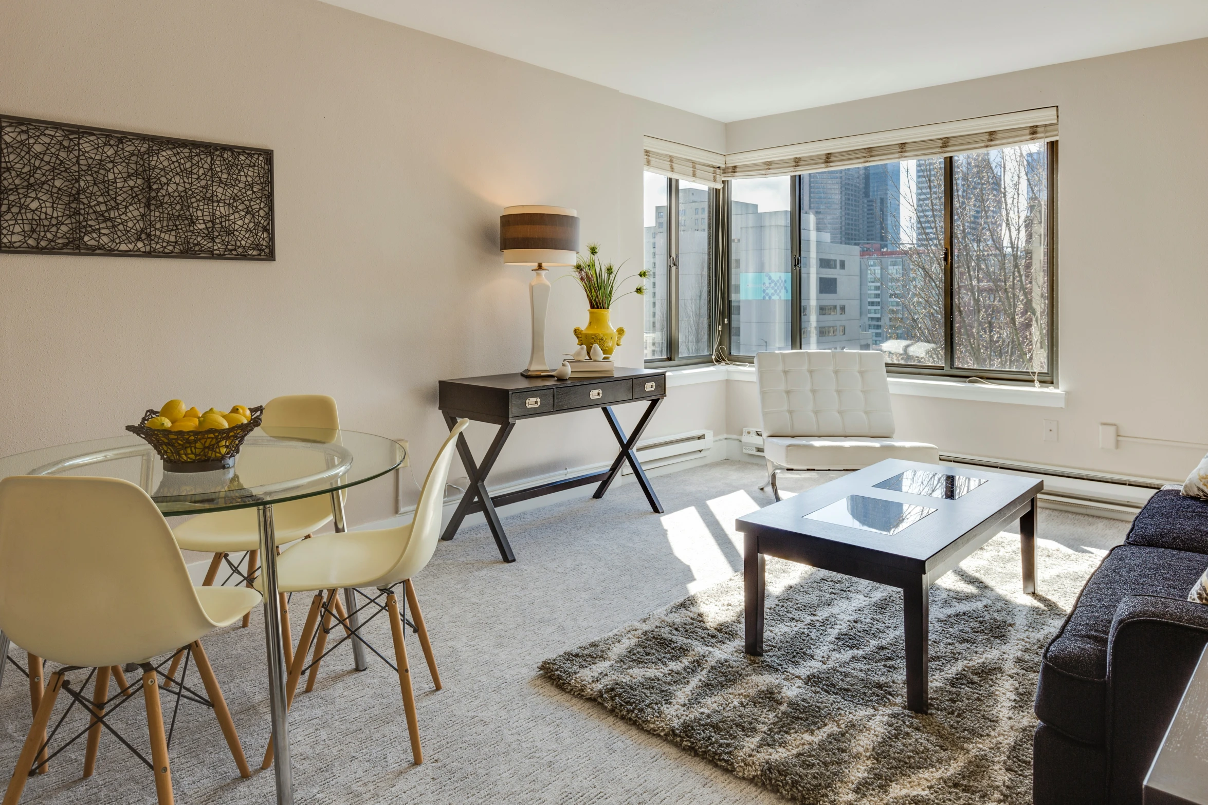 an apartment living room with the dining table surrounded by chairs