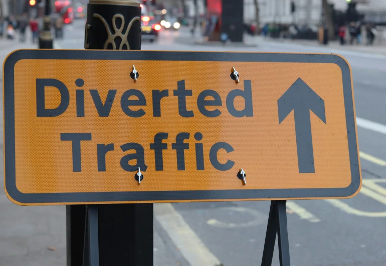 an orange sign warning of the road ahead