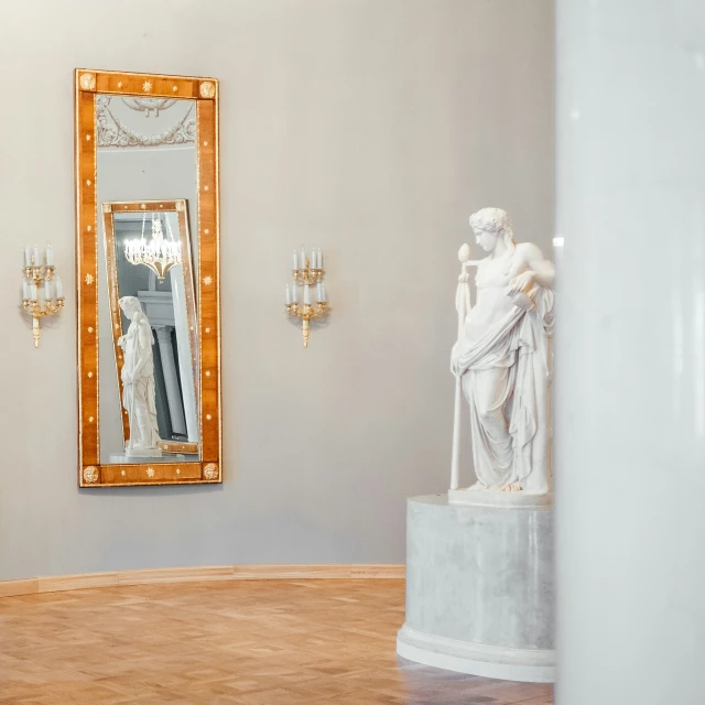 a sculpture and a mirror are in an otherwise empty space