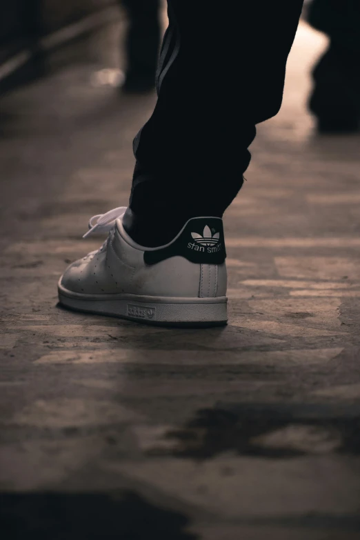 a person walking in white shoes with black and white detailing