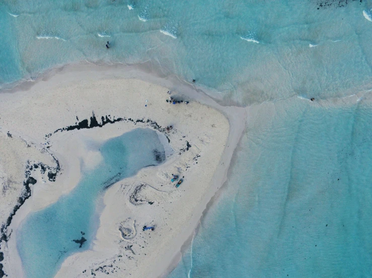 a white sand beach with blue water and waves