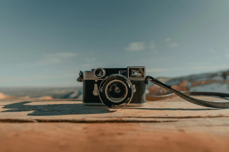 an old and outdated camera on top of a log