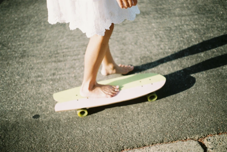 a person is walking on the sidewalk with a skateboard