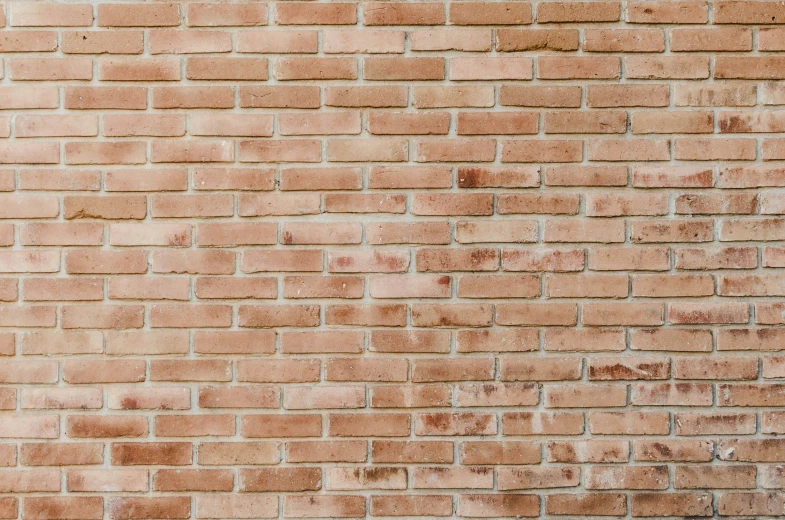 a yellow fire hydrant on the side of a brick wall