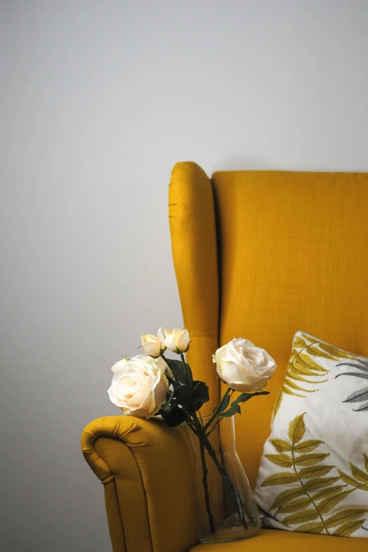 a yellow chair with flowers sitting next to it