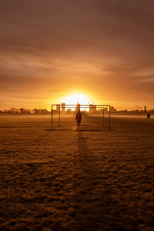 a man in the middle of an open field with a soccer goal