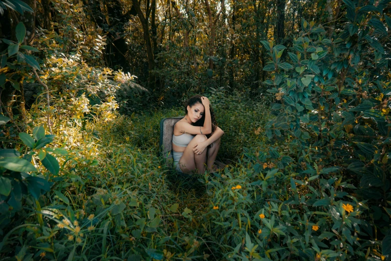 a woman is sitting in the middle of some bushes