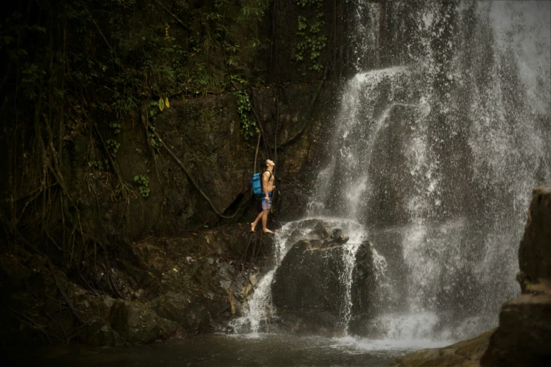 a woman standing near a waterfall that looks like it has waterfall falls