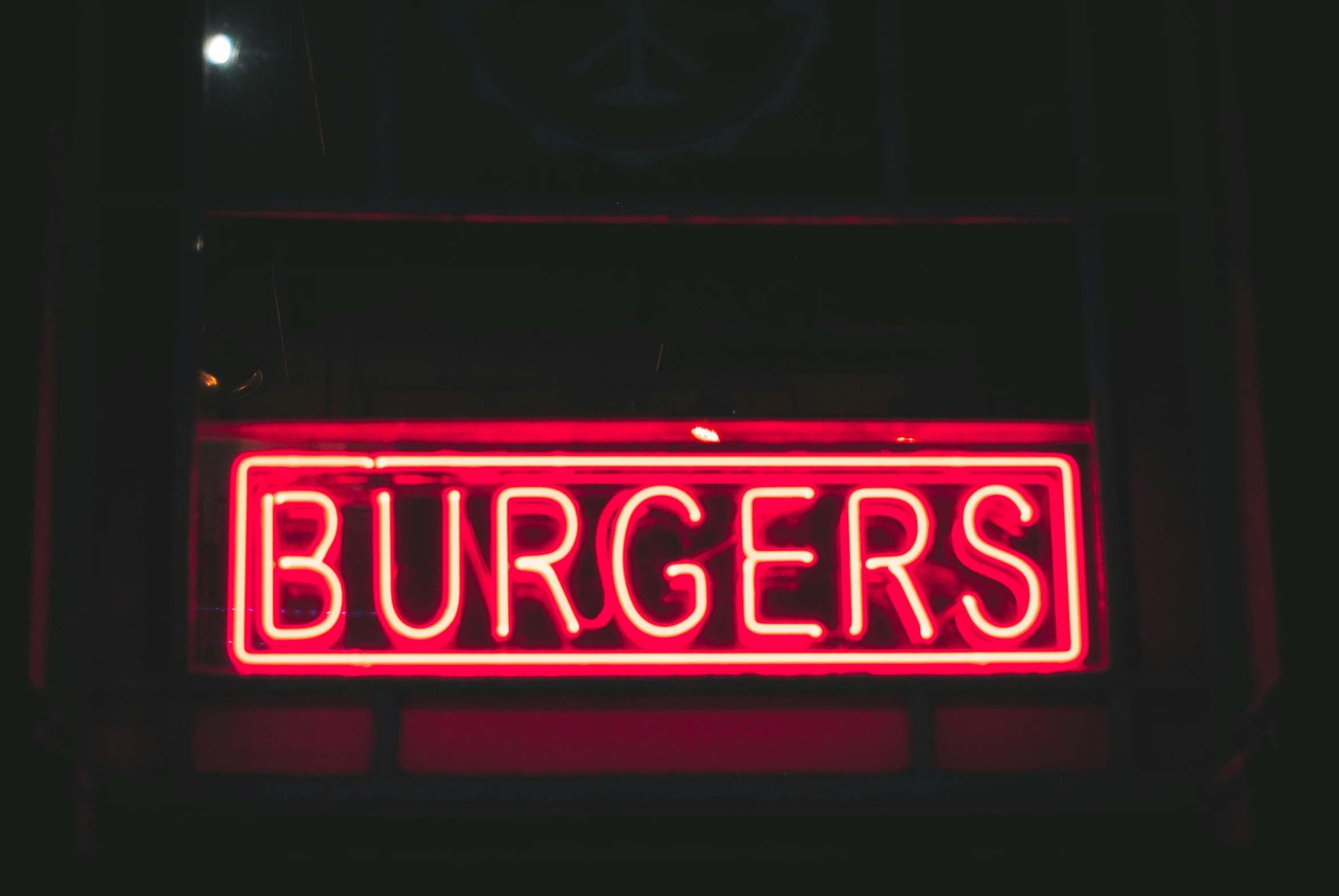 a large red neon sign reads burgers