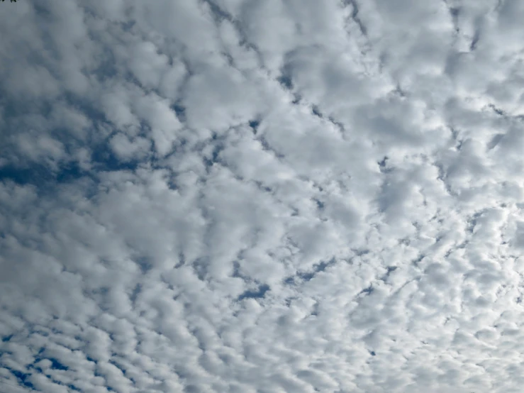 a plane flying in the sky with some clouds