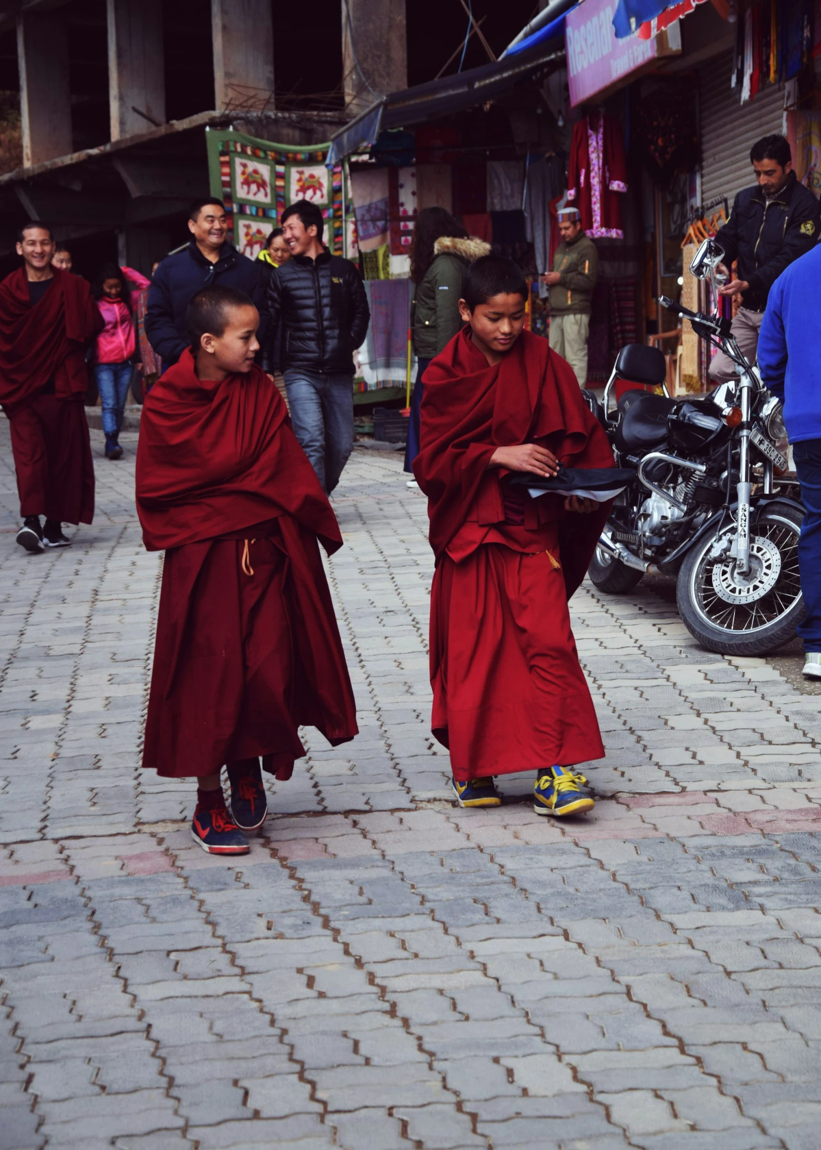 two young monks walking on a brick road
