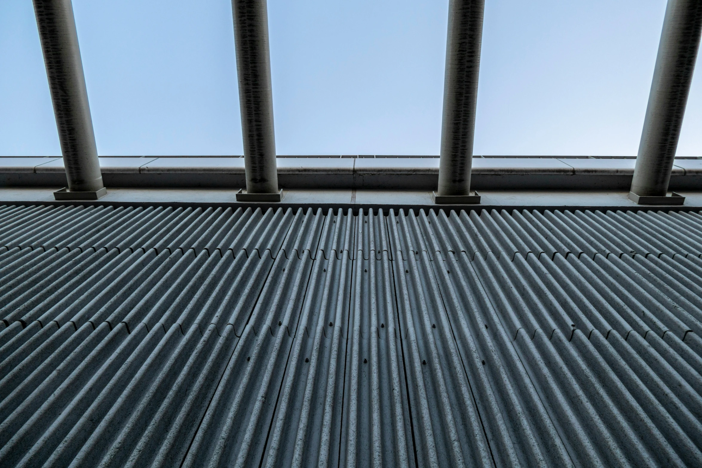 two metal poles in front of a gray surface