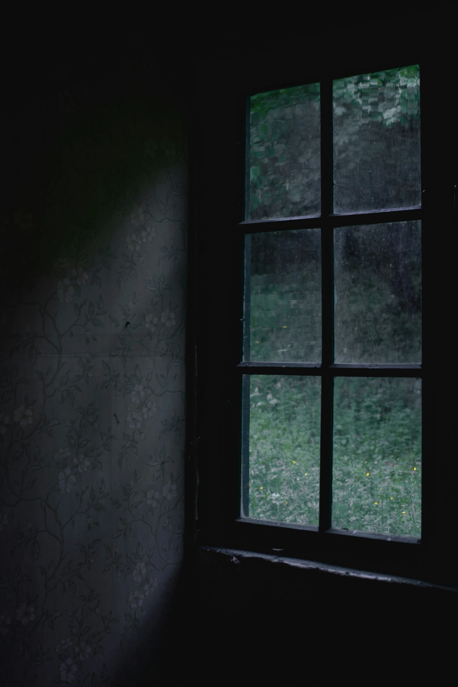 there is a dark picture outside the window of an old house