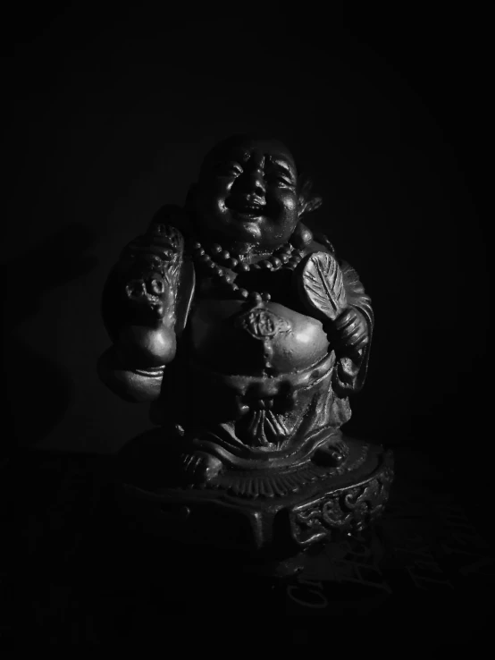 a statue sitting on top of a table with a black background