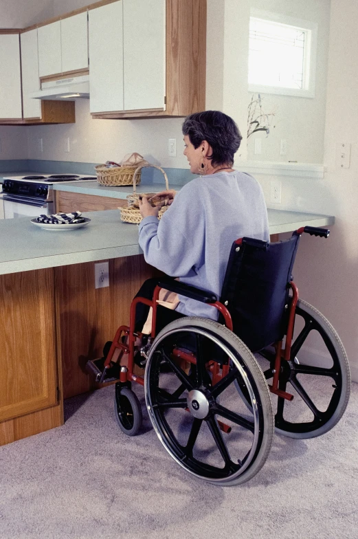 an older woman sitting in a wheel chair in a kitchen